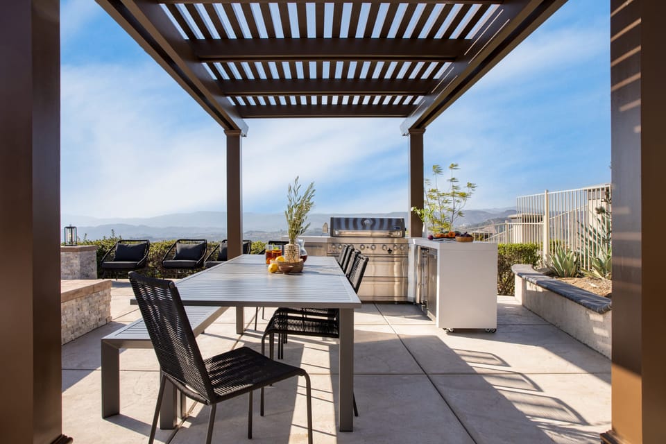 Outdoor dining table and grill near the pool.
