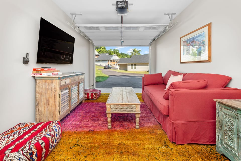 Converted garage lounge with a queen-size sleep sofa and a TV.