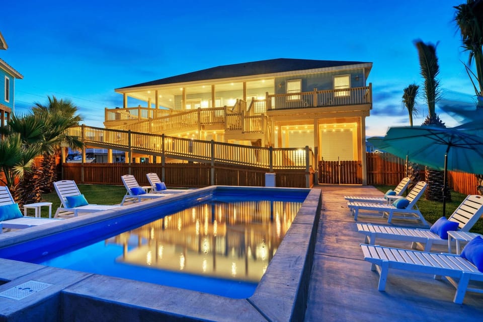 House lights illuminating the pool at night.