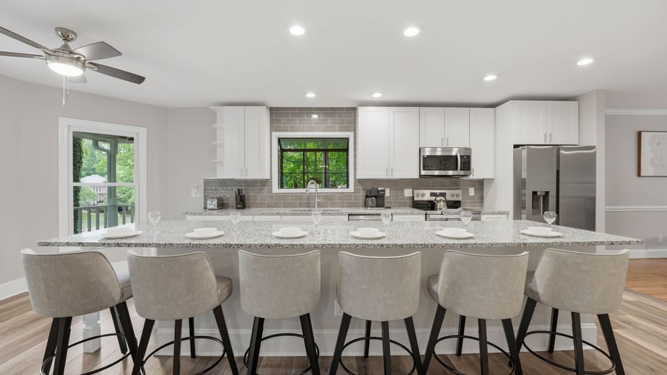 Spacious chef’s kitchen with oversized island seating and a bright, open layout made for gathering.