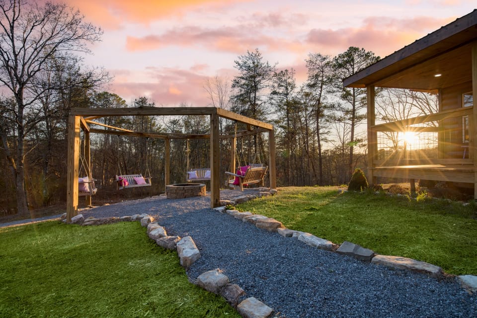 Sunset firepit lounge with swing seating and peaceful forest views.