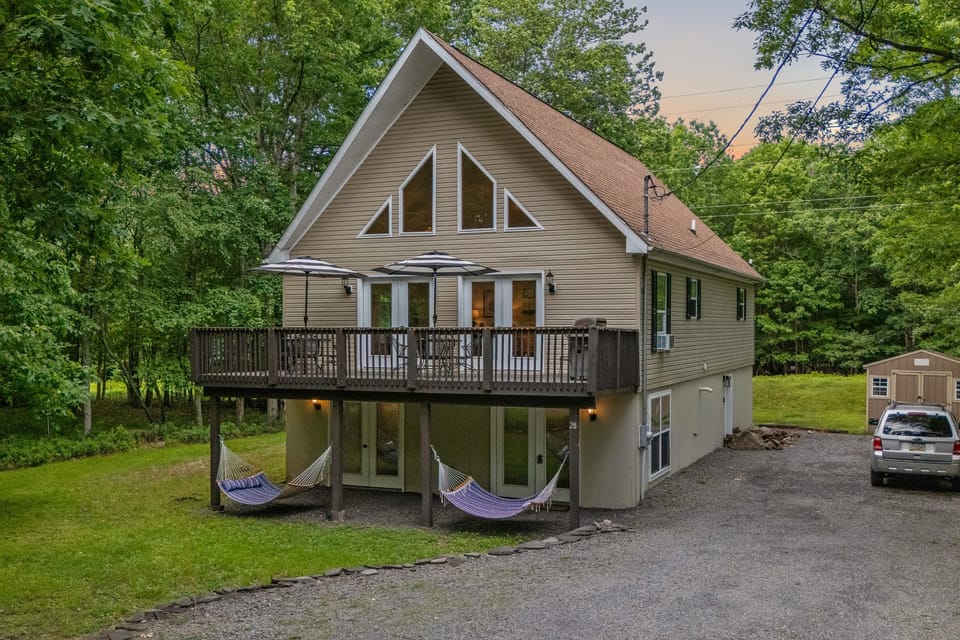This house with a big deck in the woods exudes a sense of peace and tranquility.