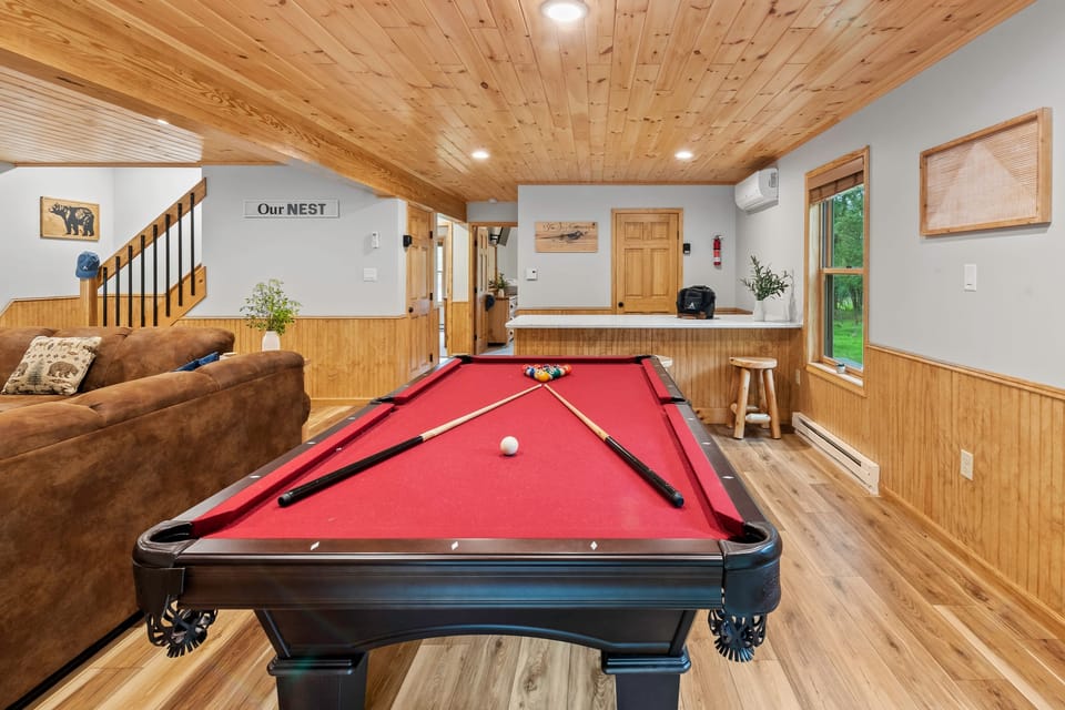 The second living area offers a pool table, a TV,  and a bar counter.