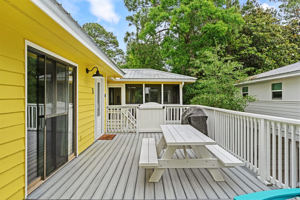 Spacious outdoor deck featuring a classic white picnic table.