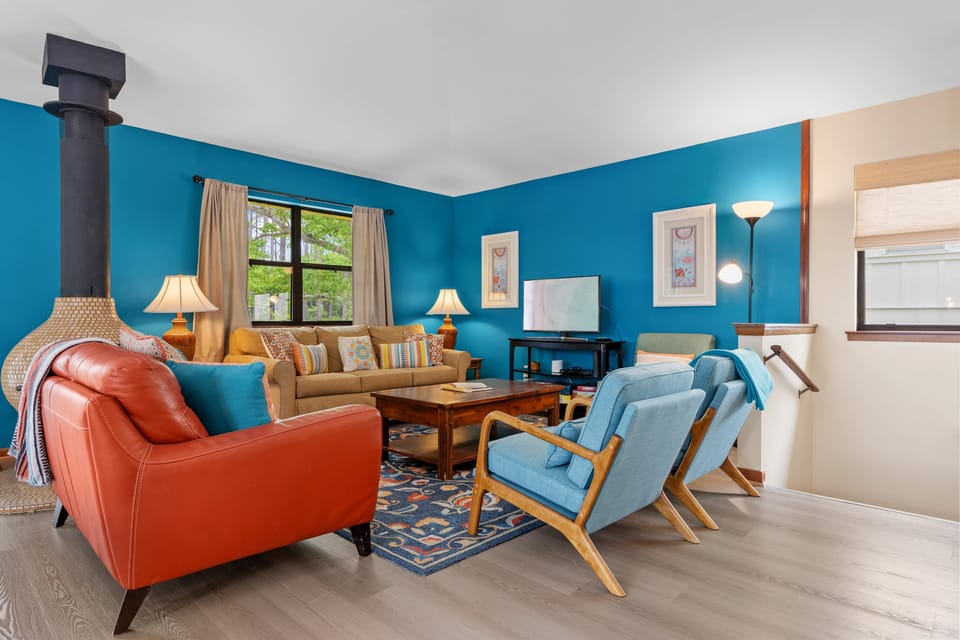 Vibrant living room with turquoise accent walls and colorful mid-century modern furniture.