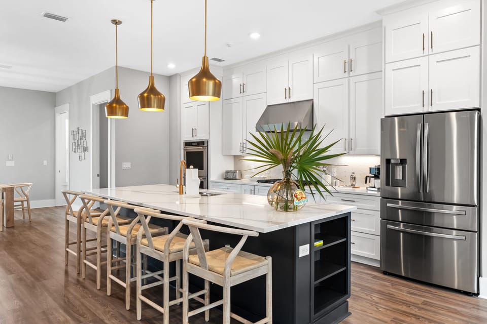 Designer kitchen with oversized island seating, stainless appliances, and statement lighting—perfect for gathering and entertaining.