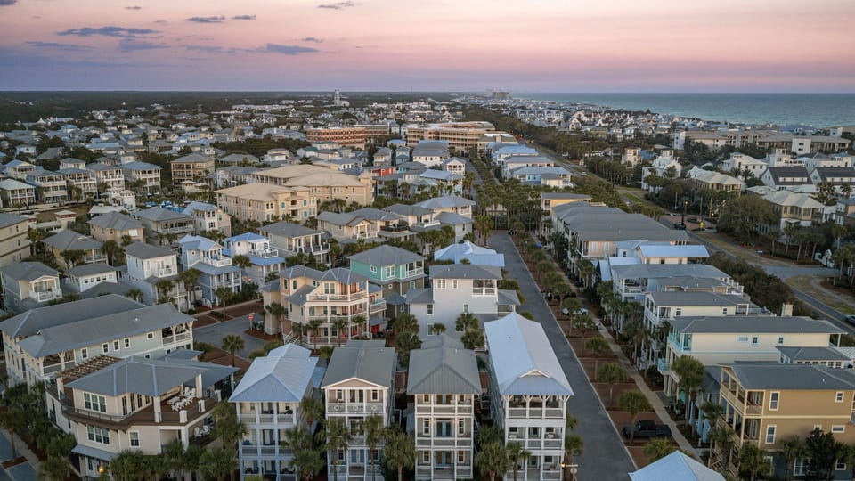 Aerial perspective of the white-sand dunes and houses.