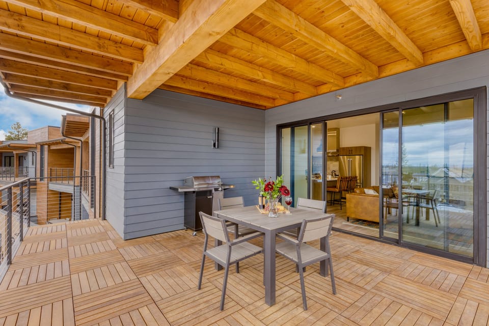 Covered private balcony with dining area and grill.