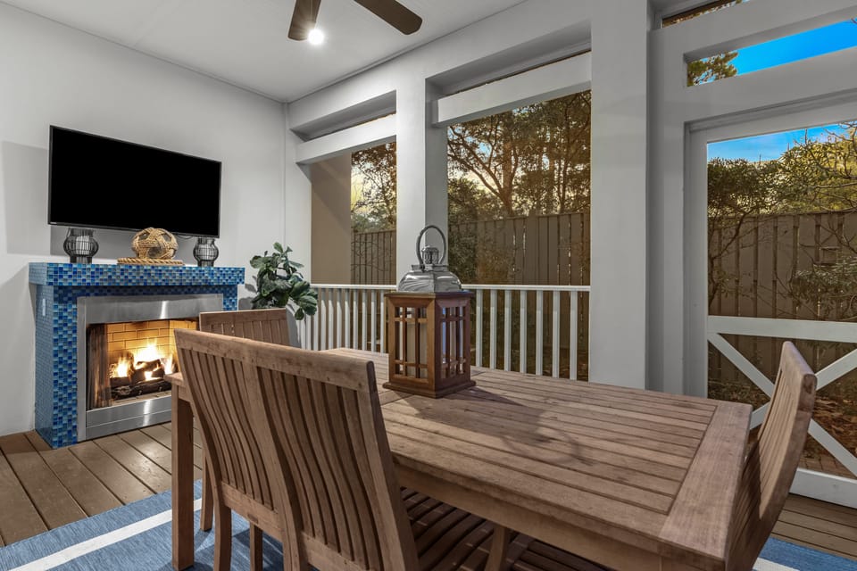 Open-air dining space with a fireplace and TV.