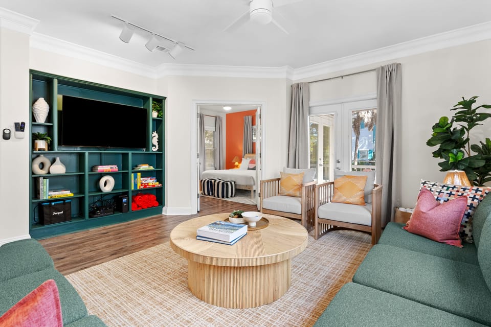 Spacious living room featuring ample seating, a large TV, and a variety of board games for endless entertainment.