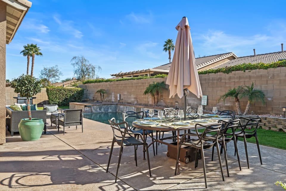 Private backyard with a pool, hot tub, and outdoor dining area.