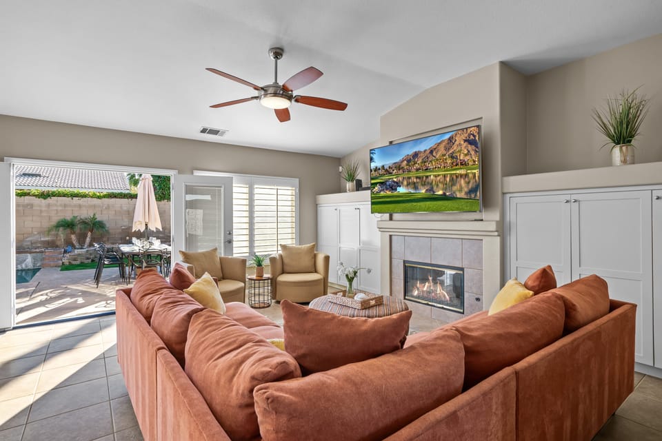 Living room offers comfortable seating, tons of natural light, a TV, and a fireplace.