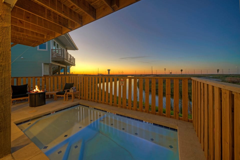 Golden hour from your private pool—unwind with panoramic sunset views over the pond and coastal sky.