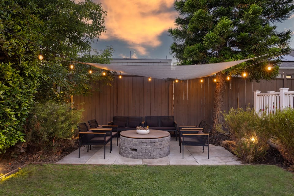 Relax by the firepit under the shaded area, a cozy spot to unwind any time of day.