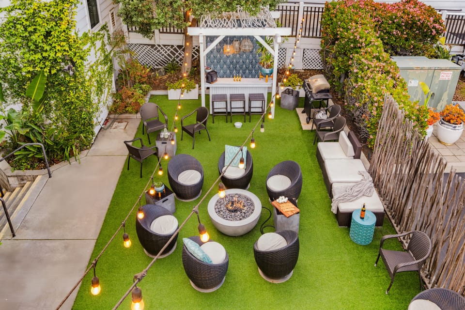 Lush backyard oasis with a cozy pergola and seating area.