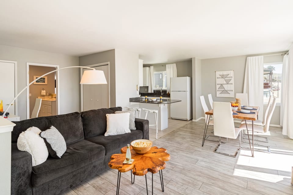 Bright and stylish living room with cozy seating and dining area. (Cayucan Bungalow 224)