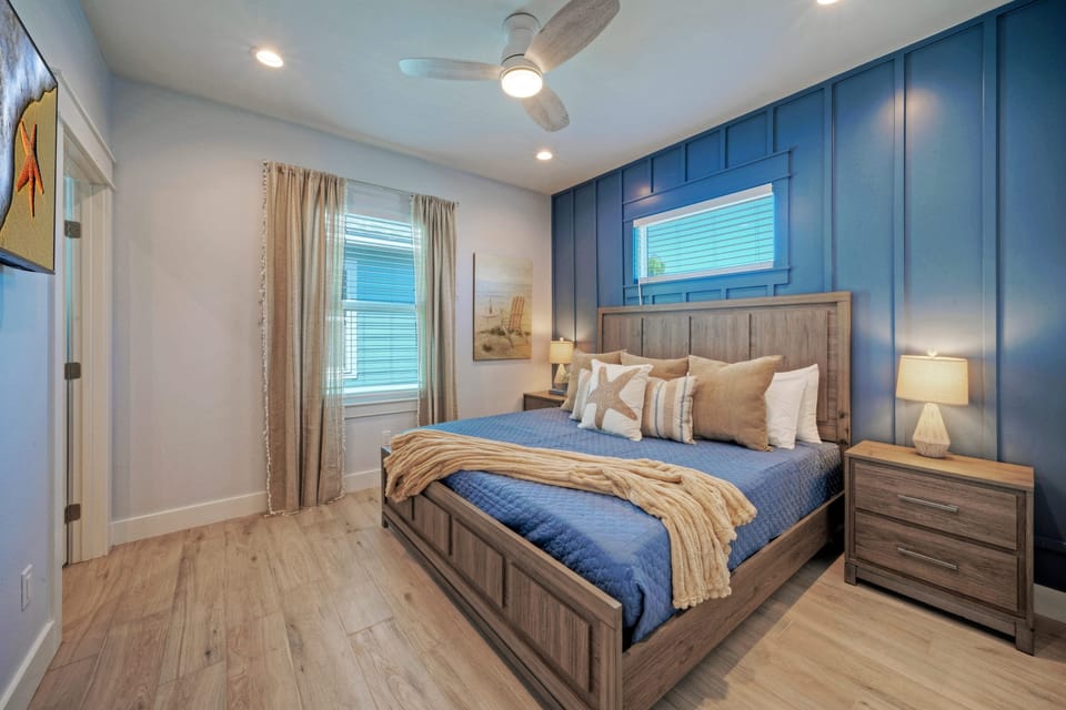Bedroom 2 with king bed, TV, closet, and private ensuite bathroom access.