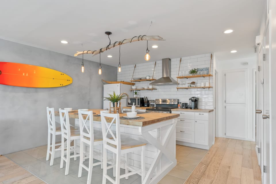 Modern kitchen with barstool seating and pendant lighting.