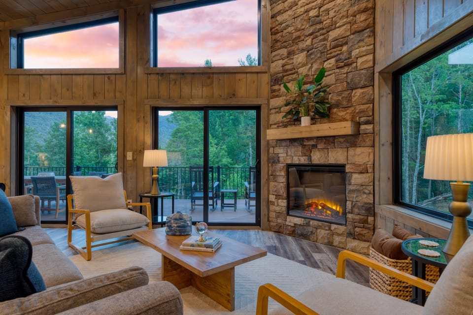 Living room with floor-to-ceiling fireplace and large windows.