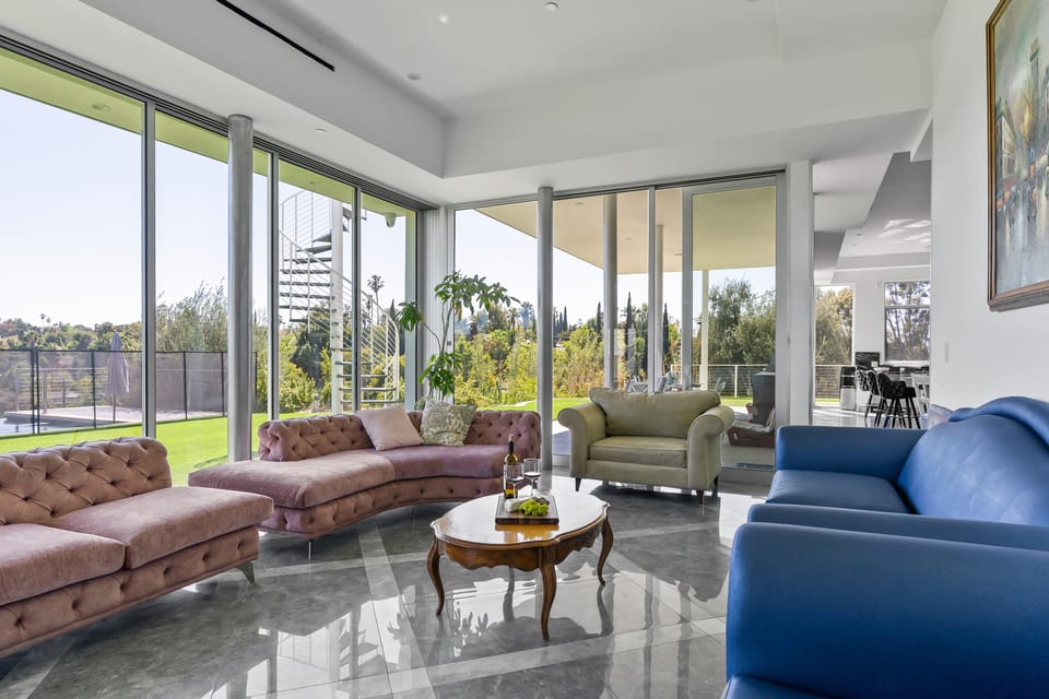 Luxurious living room with soaring windows and plush sofas made for relaxing.