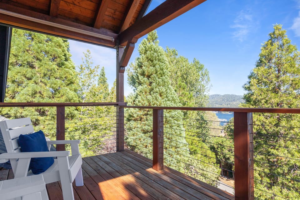 Covered deck with seating and scenic treetop views.