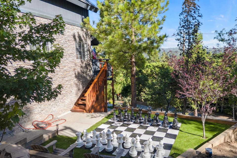 Giant outdoor chess set surrounded by greenery.