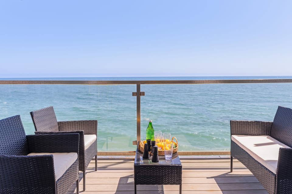 Ocean-view balcony with seating—perfect for drinks.