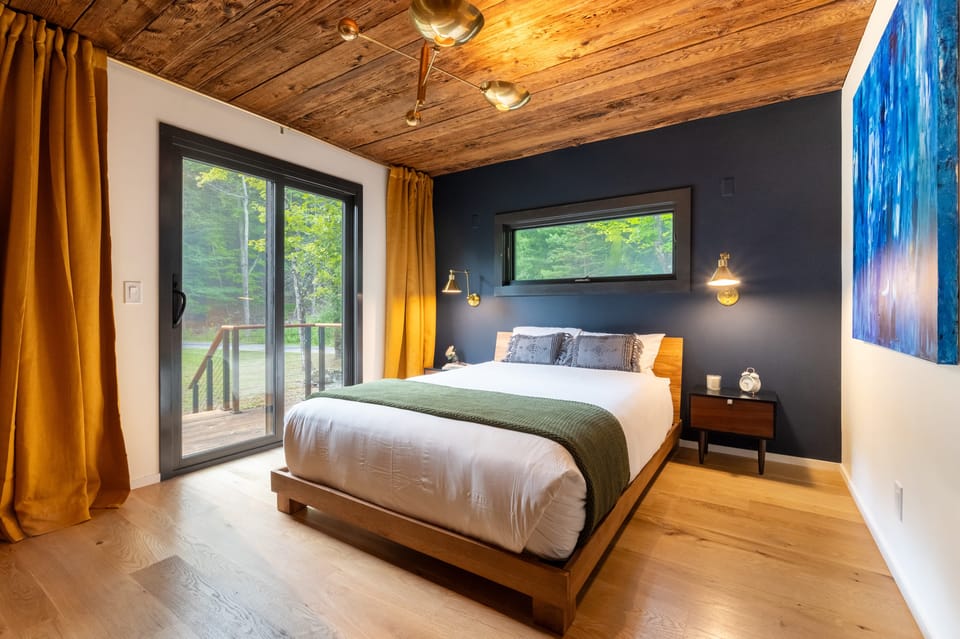 The primary bedroom features a queen bed, deck access, and an ensuite bathroom.