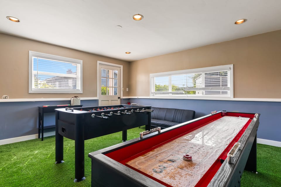 Game room with shuffleboard and foosball tables.