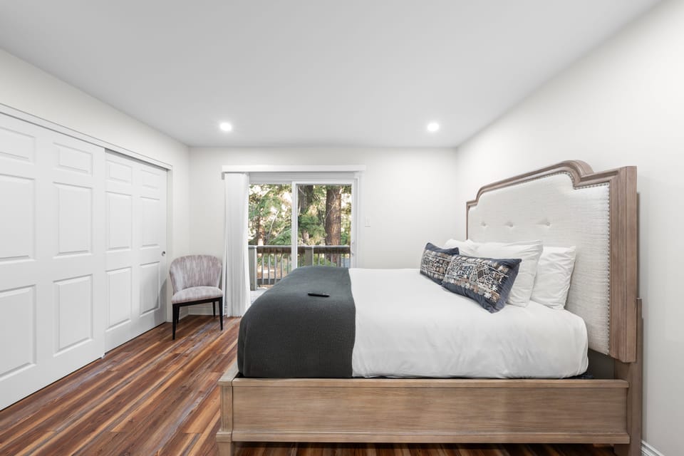 The primary bedroom features a queen bed, TV and access to the balcony.