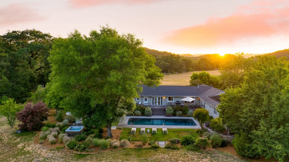 Aerial twilight view showing the home, pool, and full grounds.