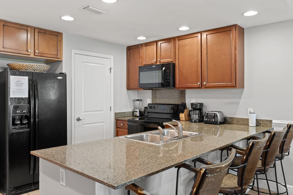 Fully equipped kitchen with barstool seating.