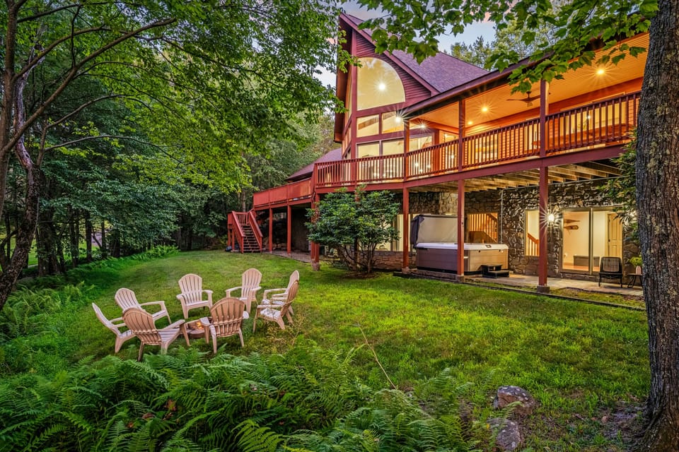 Spacious backyard with lush greenery, a cozy fire pit, and a relaxing hot tub.
