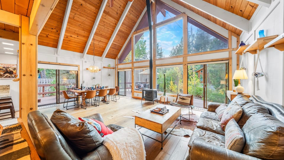 Open-concept living room with vaulted ceilings and a dramatic wall of windows.