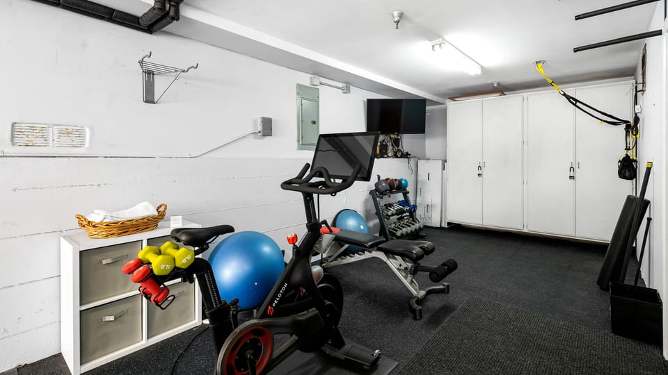 Home gym with Peloton, weights, and workout gear for a complete fitness routine.