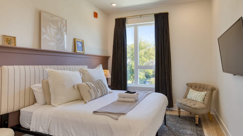 The primary bedroom features a queen bed, TV, closet, and an ensuite bathroom.