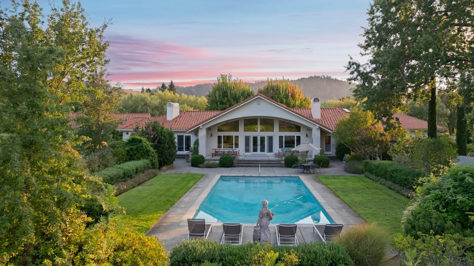 Stunning curb appeal with a beautifully landscaped front yard and sparkling pool.