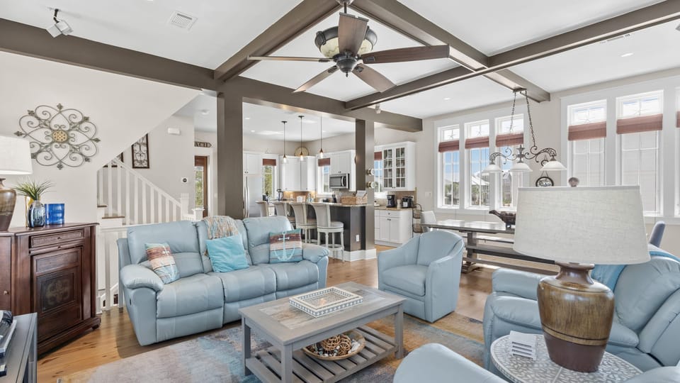 Open-concept living and dining space with exposed beams.