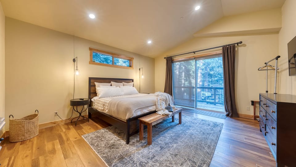 The primary bedroom features a king bed, TV, attached bathroom, and access to the deck.