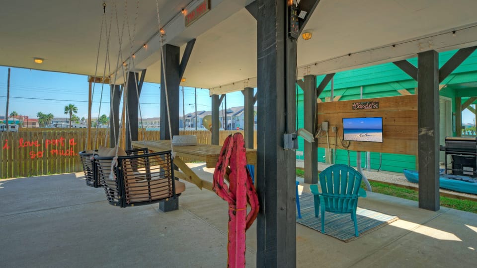 This covered patio features ample space, mood lighting, seating, and a TV—everything you need to recharge.