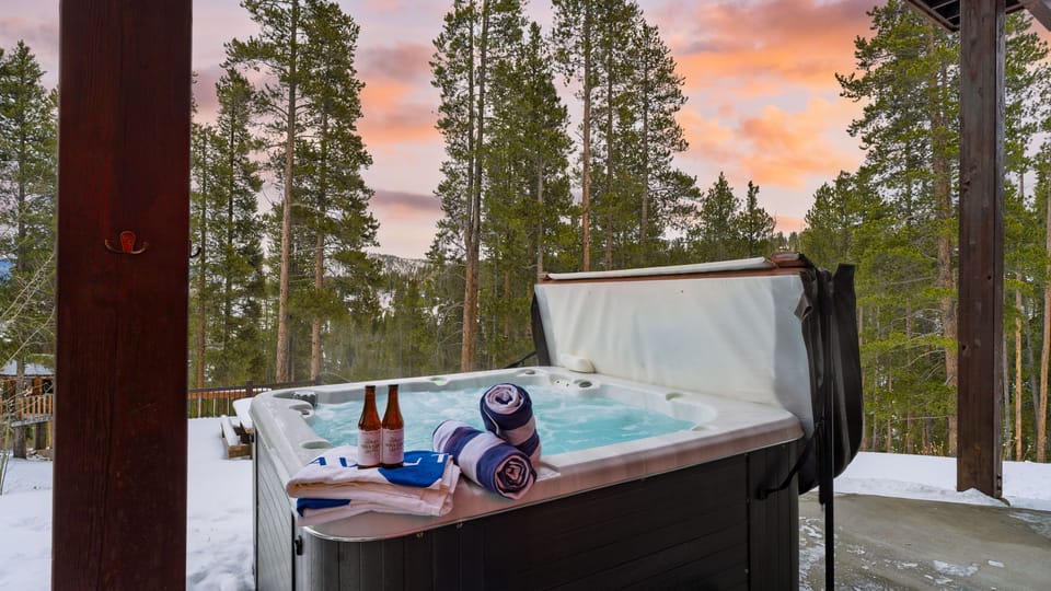 Outdoor hot tub on a deck surrounded by trees.