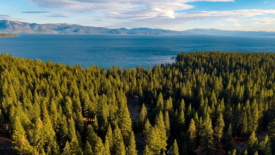 Stunning aerial view of Lake Tahoe’s crystal-blue waters and endless evergreens.