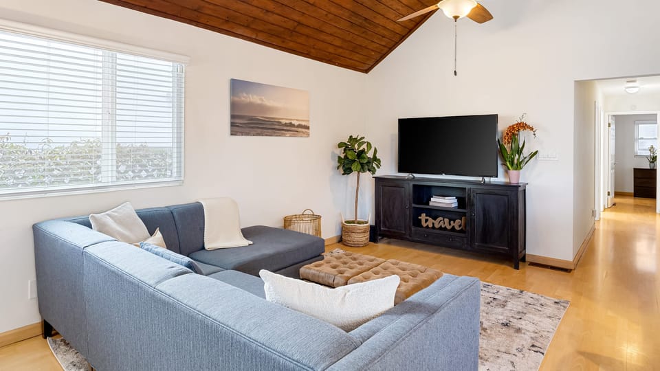 Bright, open living area with vaulted wood ceilings — perfect for relaxing after a day on the boardwalk.