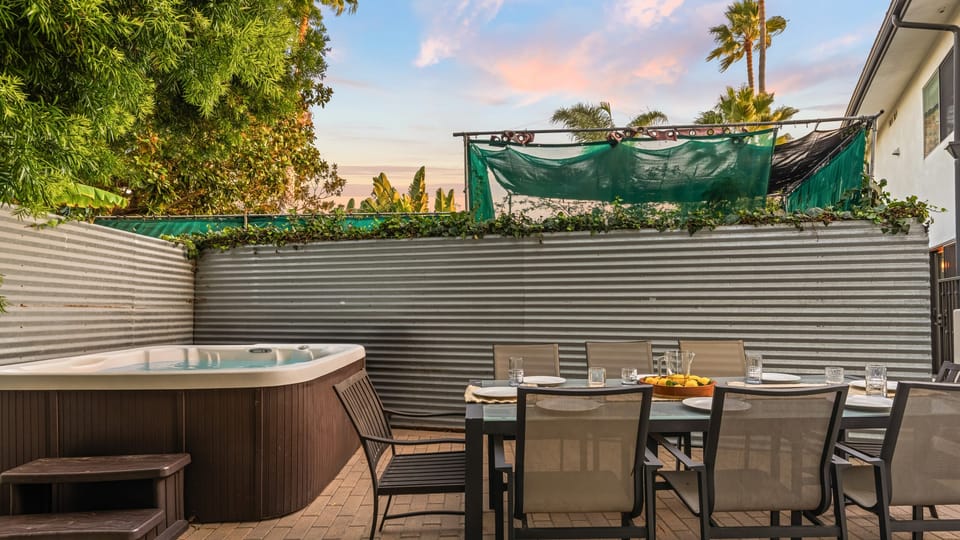 Private patio with hot tub, al fresco dining table, and privacy wall.