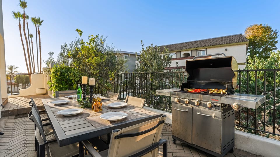 Private patio with outdoor dining table and BBQ grill.