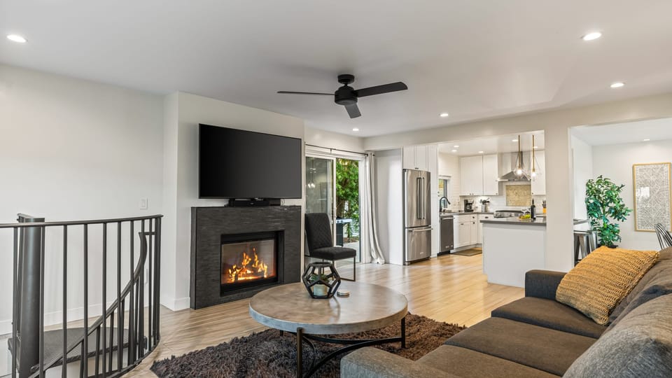Unit 2: Cozy living room with fireplace, TV, ceiling fan, and sofa.
