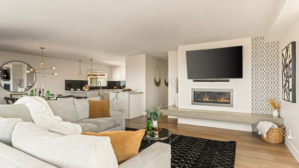 Bright and inviting living area featuring a sleek fireplace, open layout, and seamless flow into the designer kitchen. (Unit 1)