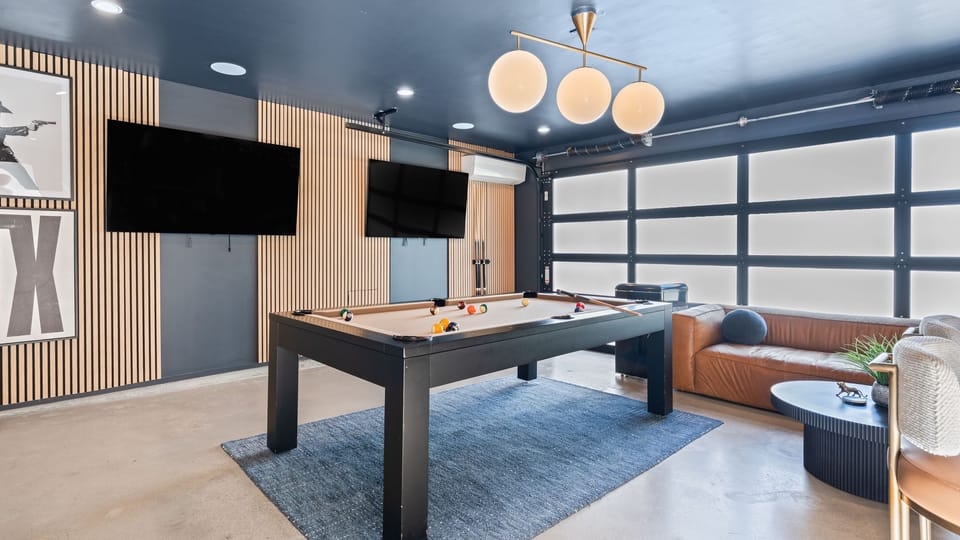 Spacious living room with a white sectional and large windows showcasing the exterior.