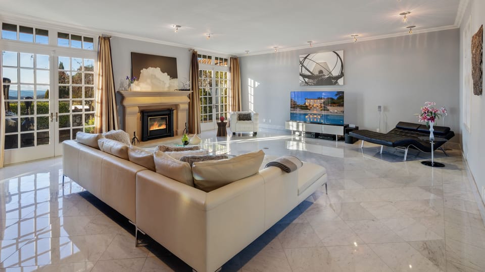 Bright, modern living room with large TV and a fireplace.