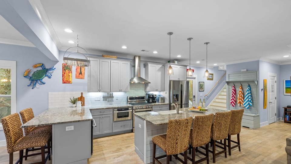 Kitchen view showing the full layout and breakfast bar with barstools.